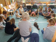 Dzieci z prowadzącą siedza na dywanie i dyskutują