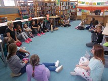 dzieci siedza w kole na dywanie