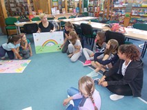 Prowadząca analizuje wykonane przez dzieci plakaty