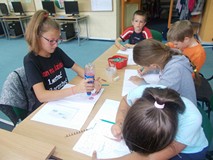 dzieci wykonują przy stole pracę plastyczną