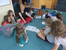 Dzieci siedza wraz z prowadzącą na dywanie i dyskutują o przyjaciołach