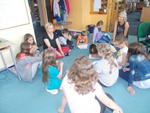 Dzieci siedza wraz z prowadzącą na dywanie i dyskutują o przyjaciołach