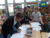 dzieci przy stoliku wykonują pracę plastyczną