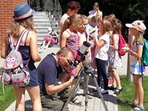 Prowadzący sprawdza ustawienia w teleskopie, za chwilę każde z dzieci będzie oglądać Słońce z bliska