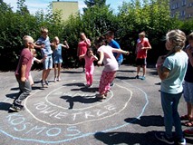 Filia nr 9. Grupa dzieci znajduje się wewnątrz trzech okręgów: środkowy to ziemia, otacza go następn