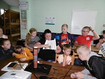 Filia nr 11. Bibliotekarka Anna Kwiatkowska pokazuje zgromadzonym wokół niej dzieciom ulice Koszalin