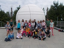 Filia nr 12. Dzieci z opiekunami stoją przed kopuła w Obserwatorium Astronomicznym w Koszalinie.