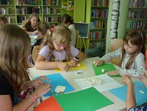 Filia nr 1. Dwa stoliki. Przy każdym czter dziewczynki mają przed sobą kolorowe kartki i masę solną,