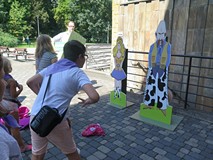 Dzieci ustawione przed figurami kowboja i kowbojki przed rzutem kapeluszem.