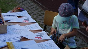 Chłopiec rozwiązuje krzyżówki dostępne na pikniku