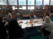 Panie siedzą przy stołach i rozmawiają