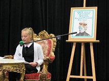 Uczestniczka konkursu Mistrzowie Pięknego Czytania 2018 czyta siedząc na stylowym krześle przy stylo