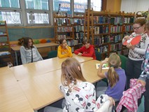 Bibliotekarka tłumaczy dzieciom, co będą robiły podczas pracy plastycznej