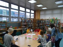 Bibliotekarki wraz z dziećmi podczas wykonywania pracy plastycznej