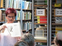 Dorota Łobacz prezentuje przedszkolakom zwój znajdujący się w magazynie w budynku głównym KBP