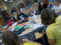 Dzieci pracują przy wspólnym stole tworząc prace plastyczne