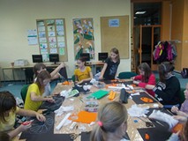 Dzieci pracują przy wspólnym stole tworząc prace plastyczne