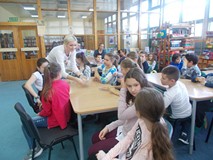 Bibliotekarka rozdaje uczniom karty SAGI