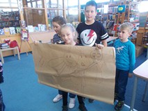 Uczniowie pozują do zdjęcia ze swoją pracą