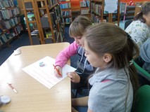 Dwie dziewczynki tworzą reklamę kolorowej taśmy klejącej