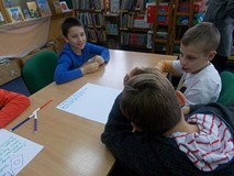 Trzech chłopców tworzy reklamę kury dzierganej na drutach