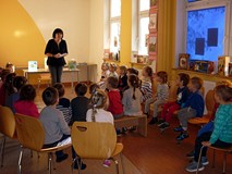 Bibliotekarka wita dzieci w bibliotece