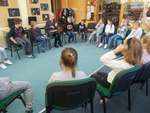 Dzieci siedza w kole słuchając czytanej książki