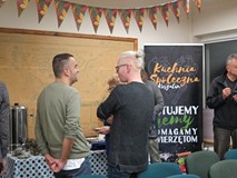 Uczestnicy spotkania z Dariuszem Gzyrą posilają się roślinnym poczęstunkiem przygotowanym w ramach K