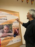 Dariusz Gzyra składa pamiątkowy autograf na plakacie promującym spotkanie