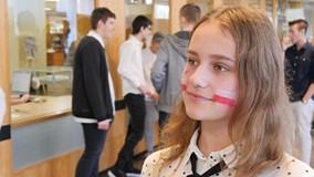 Portret kibicującej dziewczyny z flagami Polski wymalowanymi na policzkach