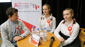 Trzyosobowa drużyna ze SP nr 18 (chłopak i dwie dziewczyny przy stoliku) biorąca udział w Turnieju W