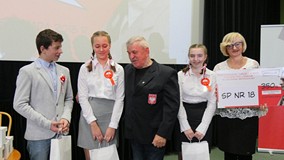 Trzyosobowa drużyna ze SP nr 18 odbiera nagrodę. Pośrodku stoi Ryszard Fornalczyk, na końcu, odprawe