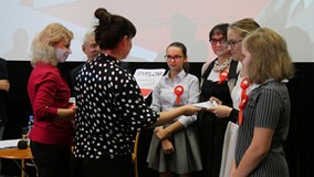 Organizatorzy wręczają nagrody jednej ze zwycięskich drużyn biorących udział w Turnieju Wiedzy o życ