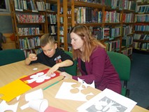 Bibliotekarka wspiera pracę chłopca
