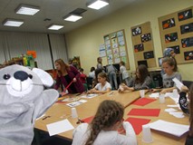 Dzieci siedzą przy stole i wykonują pracę plastyczną