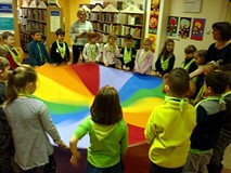 Zabawa z chustą integracyjną i misiem ZNAJDKIEM - dzieci usypiają misia