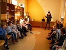 Bibliotekarka wita dzieci w bibliotece