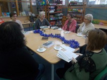 Panie siedzą przy stole rozmawiając