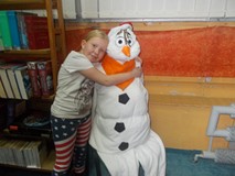 Dziewczynka pozuje do zdjęcia z bałwanem