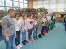 Dzieci stoją w rzędzie i wykonują wspólne zadanie