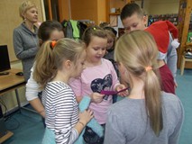 Dziewczynka czyta zadanie, które mają wykonać uczniowie