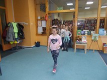 Dziewczynka idzie z książką na głowie