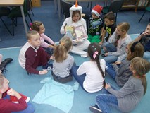 Olaf czyta dzieciom książkę na dywanie