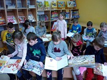 Dzieci przeglądają książeczki z wystawy BAJKOWE ŚWIĘTA