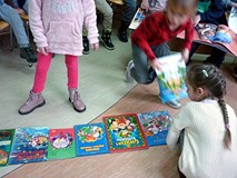 Dzieci przeglądają książeczki z wystawy BAJKOWE ŚWIĘTA