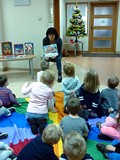 Bibliotekarka prezentuje dzieciom książeczkę ŚWIĘTA PANA MISIA. Za chwilę ją przeczyta dzieciom