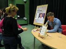 Jakub Małecki rozdaje autografy po spotkaniu w Koszalińskiej Bibliotece Publicznej