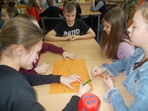 Dzieci pracują w grupach i tworzą reklamy