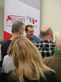 Jaś Kapela na spotkaniu z publicznością w Koszalińskiej Bibliotece Publicznej, przed nim na pierwszy