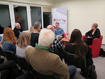 Jaś Kapela na spotkaniu z publicznością w Koszalińskiej Bibliotece Publicznej, obok niego prowadząca